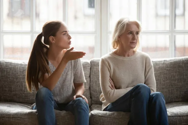 mom and daughter sitting on the couch while arguing, causing generational trauma