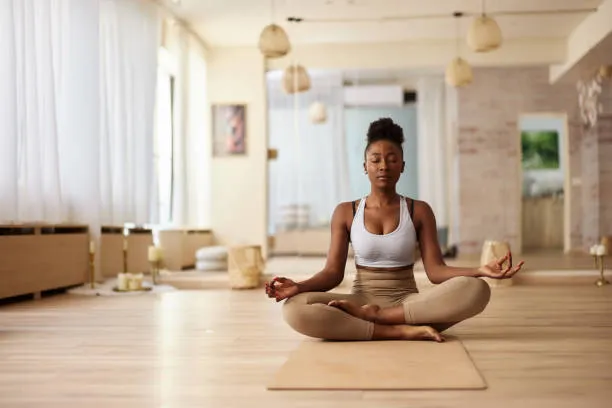 Woman sitting in a yoga studio on a mat in a meditative position